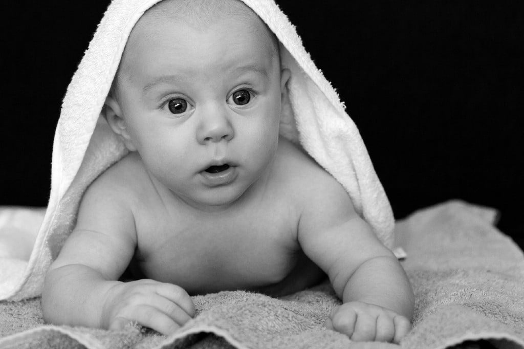 bébé avec une cape de bain sur la tête
