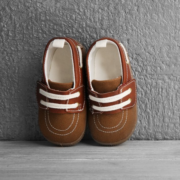 Chaussures marrons pour bébé contre un mur