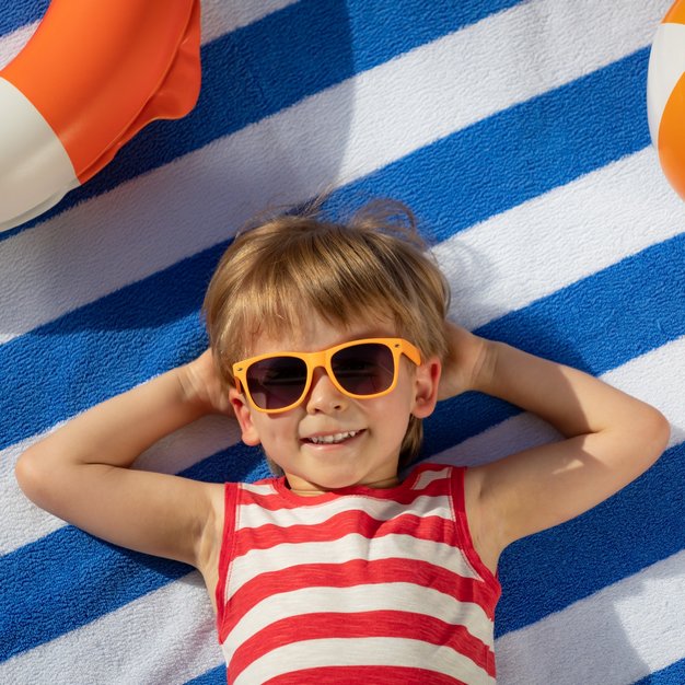 petit enfant à la plage avec des lunettes de soleil