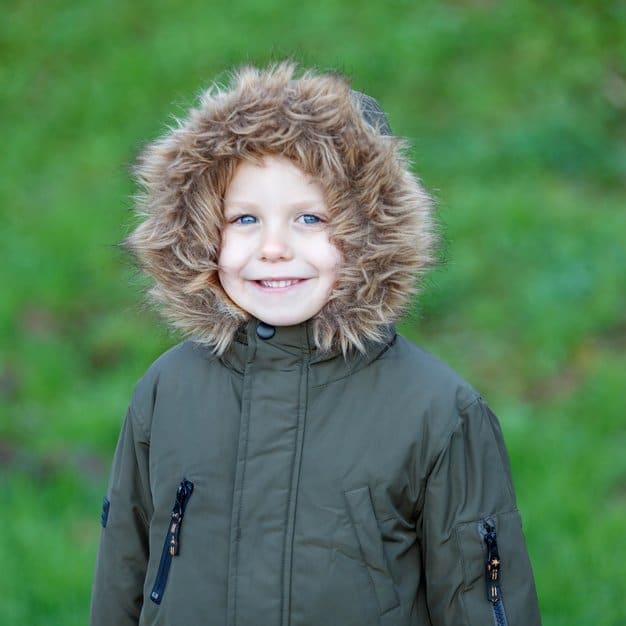 Enfant dans un park avec son manteau chaud