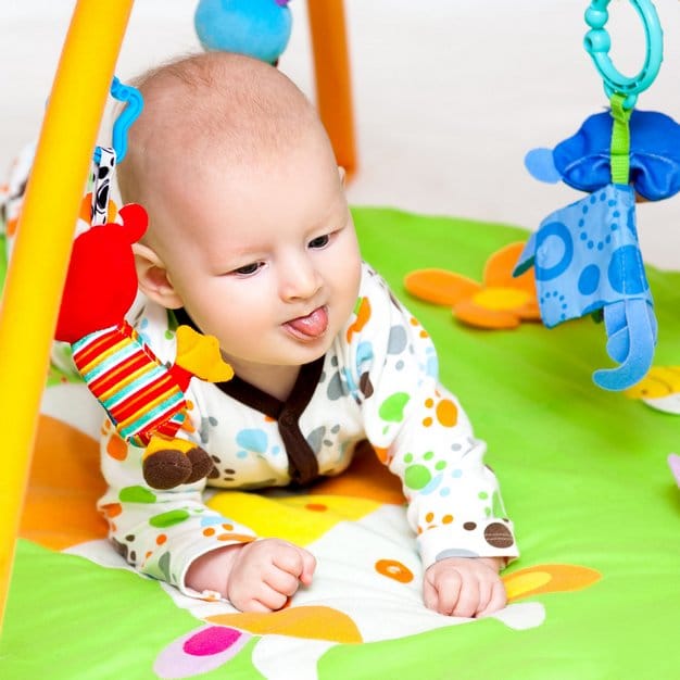 Bébé adorable sur son tapis de jeu