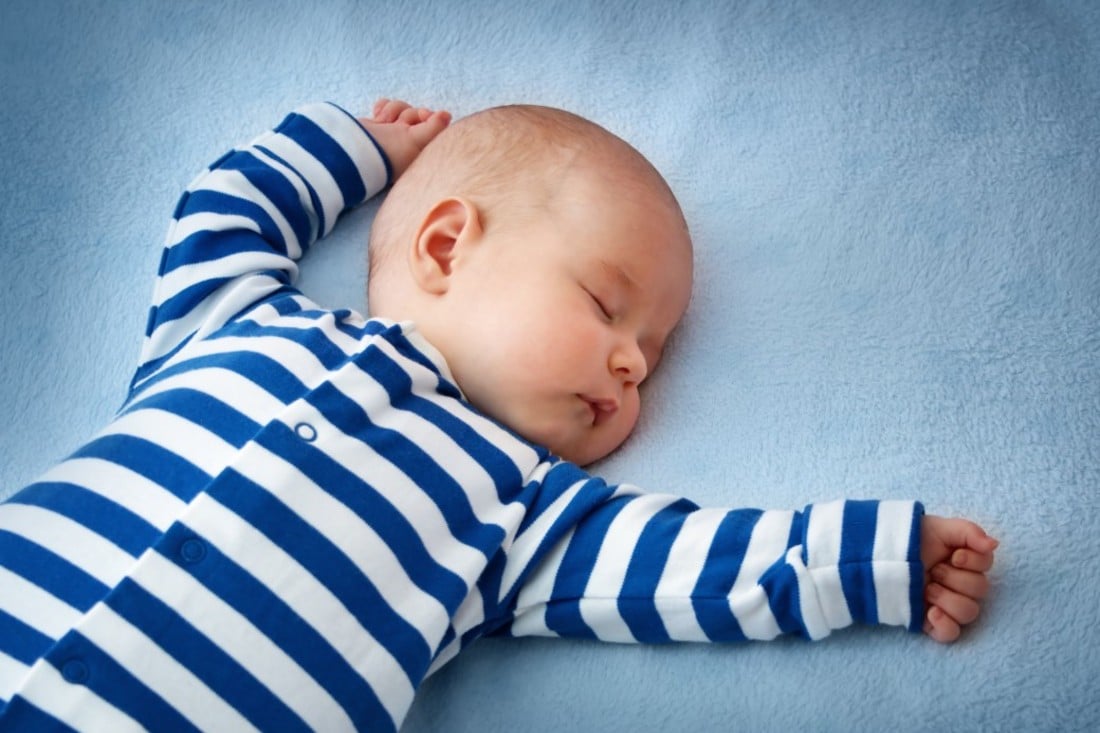 Baby schläft in blau-weiß gestreiftem Schlafanzug Mein Babyladen (1)